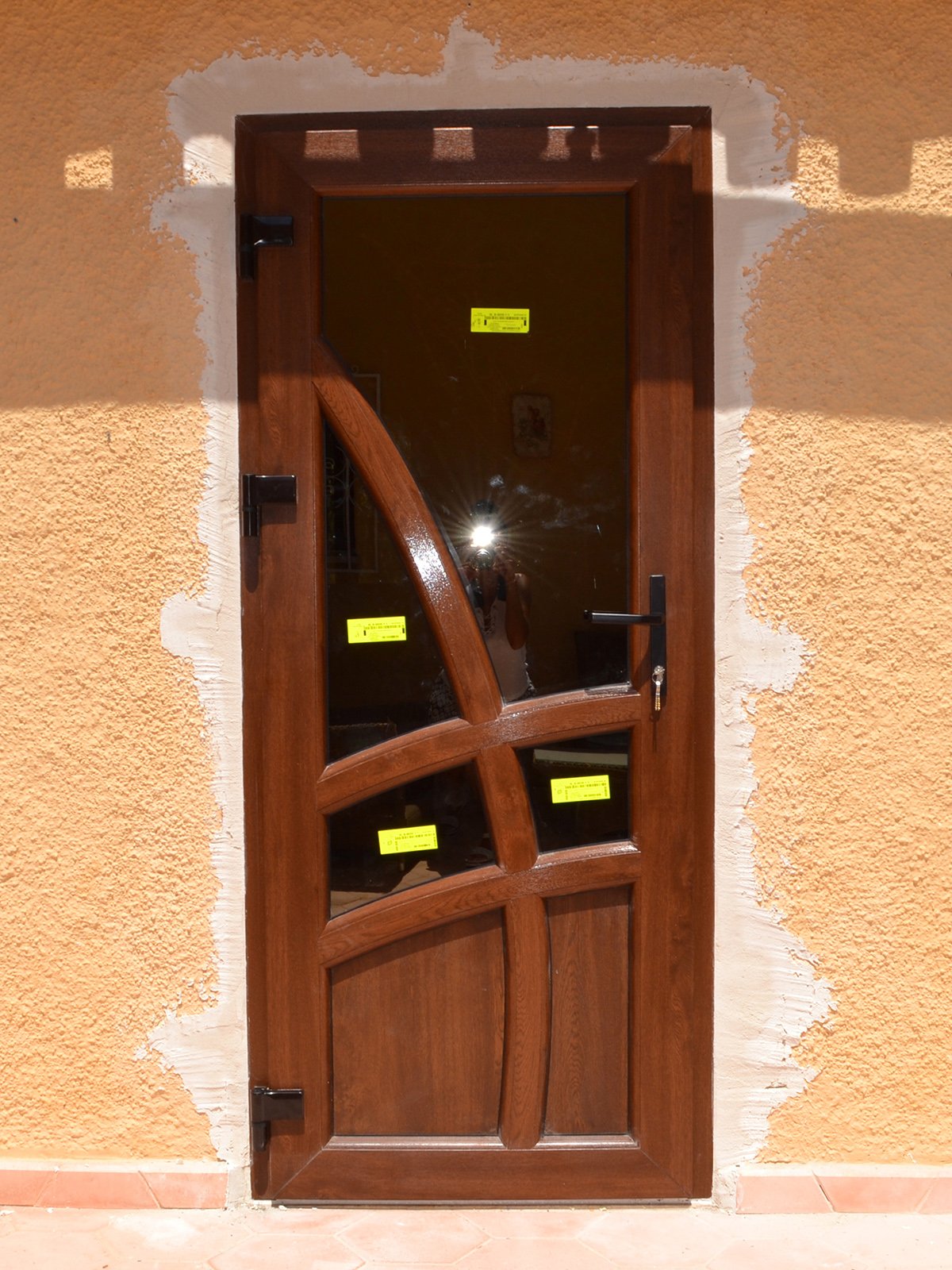 PVC REHAU entrance door with decorative pattern, reinforced hinges and handle with lock, walnut color in Javea (Valencia)